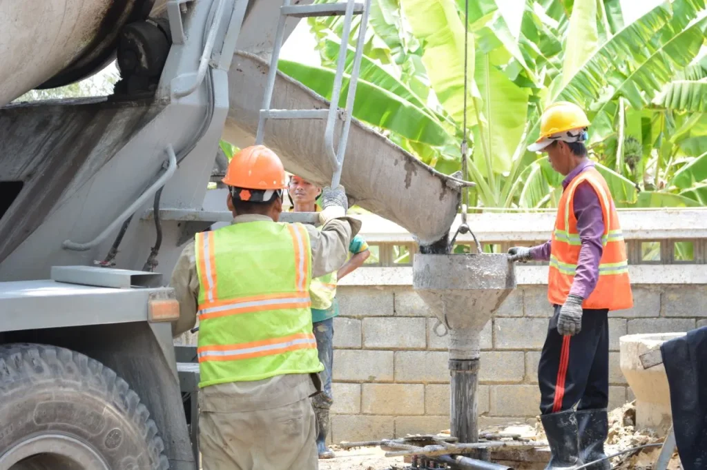 Construction workers are placing concrete with a polycarboxylate-enhanced mix for improved workability and strength in Malaysia.